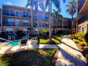 an apartment building with palm trees and a swimming pool at Surfside I 310 Condominium Condo in South Padre Island