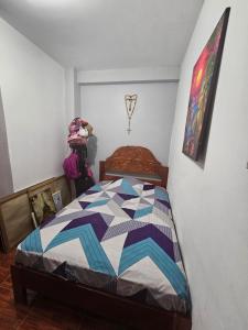 a bedroom with a bed with a quilt on it at Casa Yarinacocha in Pucallpa