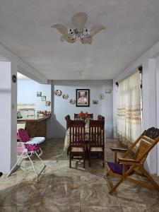 sala de estar con sillas, mesa y ventilador de techo en Casa Yarinacocha, en Pucallpa