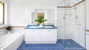 a bathroom with two sinks and a shower at Highlands on Alice in Bowral
