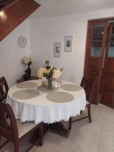 a white table with a vase of flowers on it at Hermoso y cómodo Departamento a pasos de la plaza in Tarija +7 photos