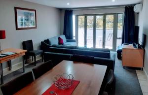 uma sala de estar com um sofá e uma mesa em Apartment Fourteen em Taupo