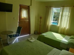 a room with two beds and a table and a window at II IMPERIO in Cieneguilla