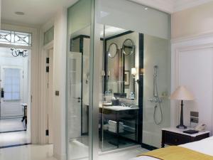 a bathroom with a glass shower and a sink at The Hermitage, A Tribute Portfolio Hotel, Jakarta in Jakarta