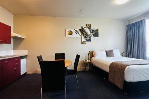 Best Western Wellington في Johnsonville: غرفة فندقية بسرير وطاولة ومطبخ