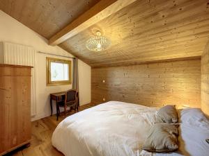 een slaapkamer met een bed en een houten muur bij Appartement Combloux, 4 pièces, 6 personnes - FR-1-560-115 in Combloux