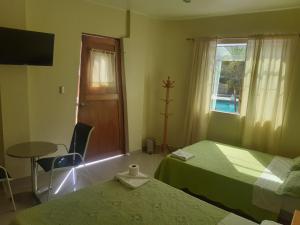 a room with two beds and a table and a window at II IMPERIO in Cieneguilla