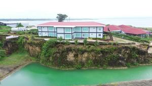 eine Luftansicht eines Hauses auf einer Klippe neben dem Wasser in der Unterkunft Marina Hotel 