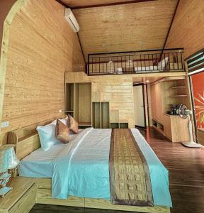 a bedroom with a large bed in a room at LePont Cat Ba Bungalow in Cat Ba