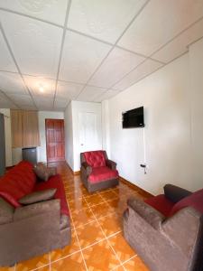 a living room with couches and a flat screen tv at MARIA III HOSTAL in Juayúa