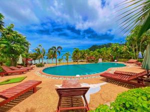 una piscina en un complejo con bancos y árboles en Diamond Beach Resort en Ao Nam Mao