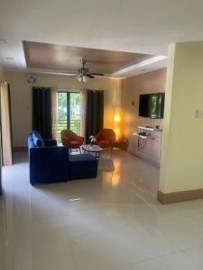 sala de estar con sofá azul y sillas en blue starfish villa en Panglao