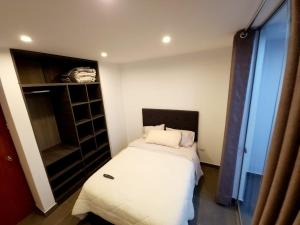 a small bedroom with a bed and a closet at Acogedor departamento en Huacachina in Ica