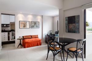 a living room with a table and chairs and a couch at Refinado Apartamento na Barra in Rio de Janeiro