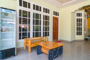 um quarto com uma mesa de madeira e um frigorífico em OYO Life 2745 Nabeza House em Duri