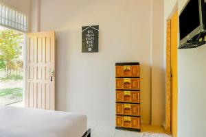 a bedroom with a dresser and a clock on the wall at OYO Life 2745 Nabeza House in Duri