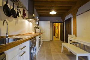 a large kitchen with a sink and a counter at La Casona de la Mesta in Almajano