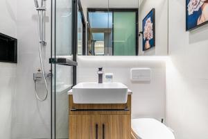 y baño con lavabo, aseo y espejo. en Yunga Yee Tsui Apartments云嘉倚翠公寓, en Guangzhou
