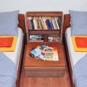 duas camas com uma mesa de cabeceira entre elas com livros em Ayki - historic centre apartment em Sófia