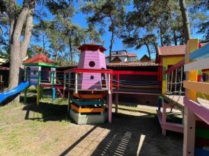 a playground with a slide in a park at Nowe domki wakacyjne blisko morza W Dziwnówku in Dziwnówek