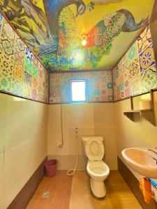 a bathroom with a toilet and a sink at Aquaholik Traveler's Lodge in El Nido