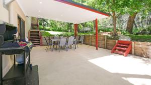 a patio with a table and chairs under a pavilion at Fern Creek Cottage in Berrima