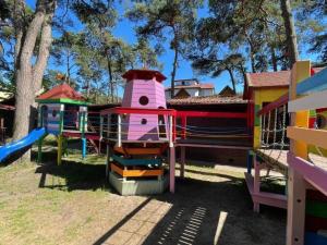 um parque infantil com uma estrutura colorida para brincar num parque em Comfortable holiday homes for 6 people, close to the sea em Dziwnówek