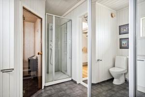 La salle de bains est pourvue de toilettes et d'une douche à l'italienne. dans l'établissement Idyllisk hus ved sjøen, à Hammerfest