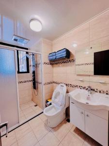 uma casa de banho com um WC, um chuveiro e um lavatório. em 蘭田山館宜蘭民宿包棟Lantian em Ch'in-hsiang