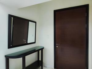 a bathroom with a mirror and a wooden door at Apartement The Peak Sudirman in Jakarta