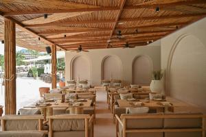 un restaurante con techos de madera, mesas y sillas en Arinara Beach Resort Phuket - SHA Extra Plus, en Bang Tao Beach