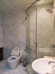 a bathroom with a shower and a toilet and a sink at Apartement The Peak Sudirman in Jakarta