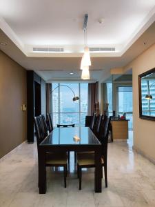 a dining room with a black table and chairs at Apartement The Peak Sudirman in Jakarta