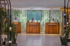 three women are standing behind podiums in a room at Occidental Eden Beruwala in Bentota