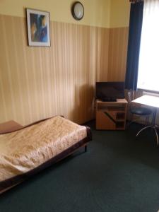 1 dormitorio con cama, escritorio y mesa en Max na terenie stacji MOL, en Radzymin