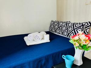 a blue table with towels and a vase with flowers at Sea Residences - Angel Alano in Manila