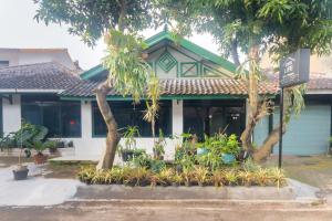 een huis met bomen en planten ervoor bij OYO Life 3055 Rumah Enin in Bandung
