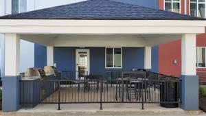 Casa colorida con terraza con mesas y sillas. en Candlewood Suites - Lake Charles South, an IHG Hotel en Lake Charles