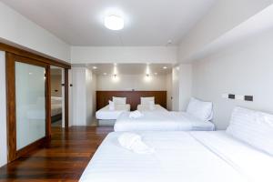 two beds in a white room with a mirror at A Sleep Bangkok Sathorn in Bangkok +112 photos