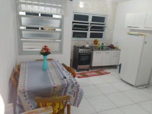 a kitchen with a table with a vase of flowers on it at AP beira mar perto do centro in Capão da Canoa