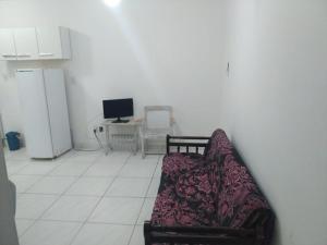 a living room with a couch and a tv at AP beira mar perto do centro in Capão da Canoa +3 photos
