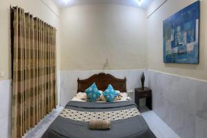 1 dormitorio con 1 cama con almohadas azules en Sagita Bungalow, en Gili Trawangan