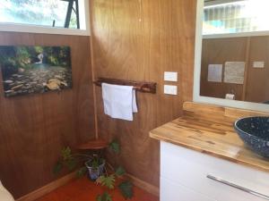 a bathroom with a sink and a counter with a window at First Light Rangihaeata Retreat in Takaka
