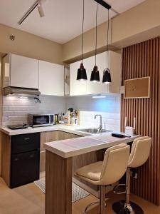 a kitchen with a sink and a counter with two chairs at Iloilo Travellers Zen Zone in Iloilo City