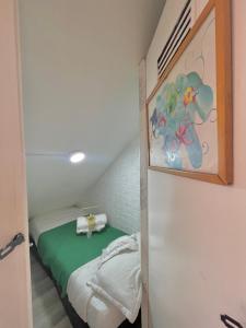 Habitación pequeña con cama y pintura en la pared en Prisma Hostel, en Bogotá