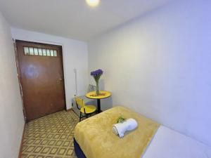 a room with a bed and a table and a door at Prisma Hostel in Bogotá
