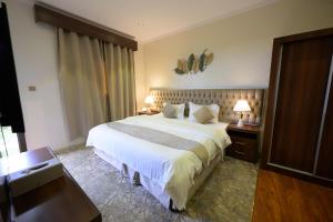 a bedroom with a large bed in a hotel room at رمال الجزيره in Al Ḩawīyah