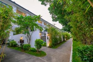 a white building with trees in front of it at Hotel Seoul in Clark