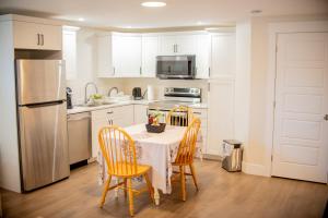 y cocina con mesa, sillas y nevera. en Cozy One bedroom Apartment en Moncton