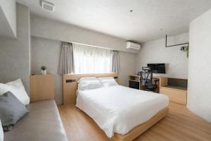 1 dormitorio con 1 cama blanca grande y TV en 脈 -MYAKU PRIVATE SAUNA- en Fukuoka